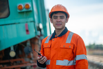 Construction engineer inspecting railway track industrial documents in hand while examining rail structure closely construction, safety and professional project management transportation development.