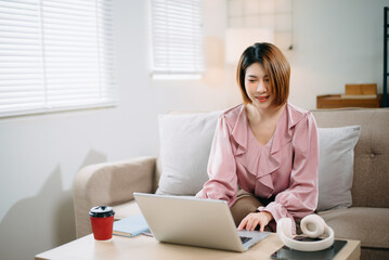 young asian woman working at home with laptop, freelancing concept