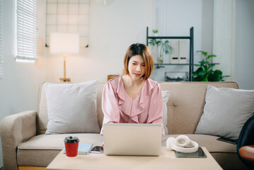 young asian woman working at home with laptop, freelancing concept