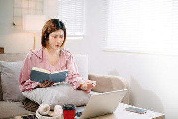 young asian woman working at home with laptop, freelancing concept