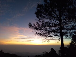 Fototapeta premium The morning sun rises on the summit of Doi Fah Hom Pok in northern Thailand.
