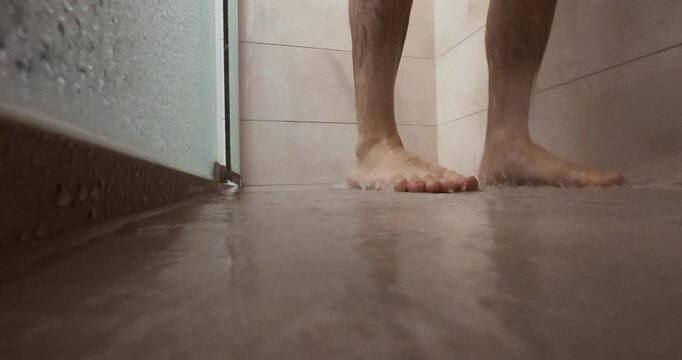 A realistic close-up of a man losing balance and slipping on a wet shower floor &mdash; a dramatic hygiene and safety moment highlighting the risk of household accidents.