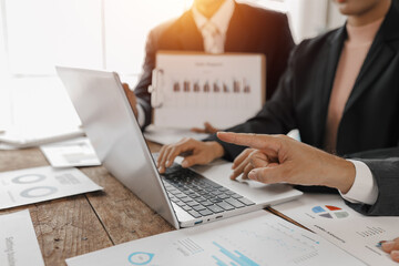 Fototapeta premium Business people are collaborating, analysing financial data and planning strategies, using a laptop and various charts