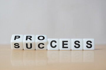 Process for success concept. White dice flip over word process to success on wood table