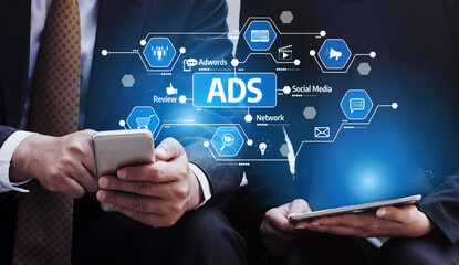 Two business professionals examine digital marketing strategies through mobile devices, highlighting the importance of advertisements and online engagement for success. Tessel