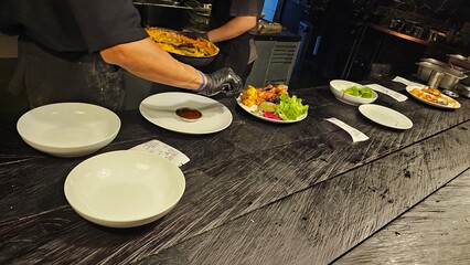 Chef preparing a gourmet salad and steak. Chef plating food at a fine dining restaurant