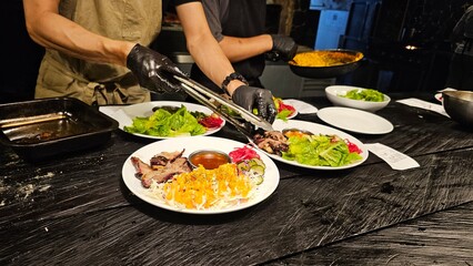 Chef preparing a gourmet salad and steak. Chef plating food at a fine dining restaurant