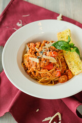 A delicious plate of spaghetti bolognese, beautifully presented with garnish
