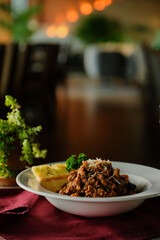 A delicious plate of Bolognese pasta with garlic bread