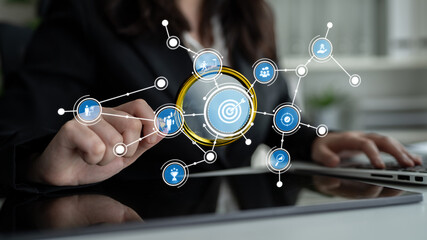 A business professional engages with an advanced digital interface filled with various icons representing analytics, technology, and progress in a modern office environment. Tessel