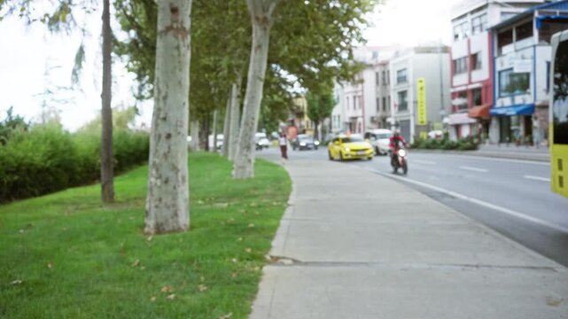 Defocused istanbul street scene with soft bokeh sidewalk, tree line and blurred curb background; background backplate copyspace.