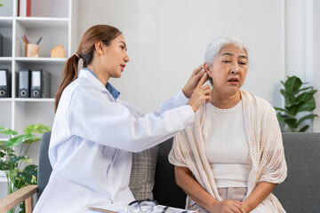 Healthcare professional performing an ear examination on an elderly patient, assessing hearing...