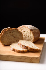 French country sourdough bread sliced on black background