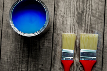 painting at home with can blue paint on wooden background