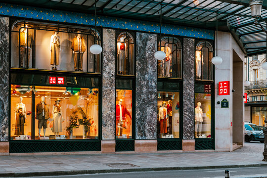 Uniqlo flagship store exterior with illuminated mannequins and marble details. Paris, France - 5 April 2025