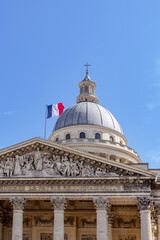 Obraz premium Majestic Pantheon dome with French flag waving under clear blue sky, symbol of French national pride