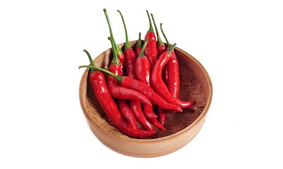 High angle view of Red hot chili peppers on bamboo bowl. Isolated on white background with copy space. Clipping path. Perfect for design element, spicy food concept or any commercial usages. 