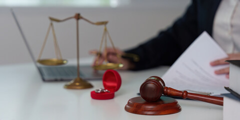 Legal Consultation. A lawyer reviewing documents with a gavel and scales on the table.