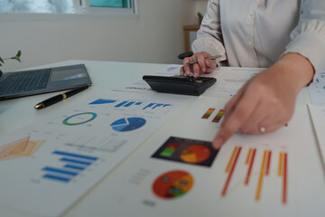 Data Analyst Reviewing Charts and Graphs with Calculator