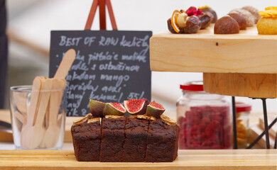 Sweet banana bread topped with fresh figs and raw dessert balls displayed at the Naplavka farmers market in Prague.