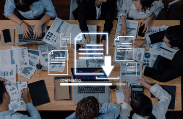 A diverse group of professionals engaged in a collaborative business meeting, analyzing reports and downloading documents on various digital devices in a modern office setting. Trope