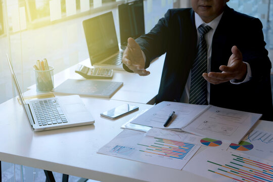 executive businessman sit down use computer tablet with graph chart on analysis data table
