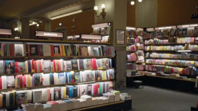 Blurred bookstore shelves and stacked books with warm soft shallow bokeh interior background; background copyspace backplate calm.