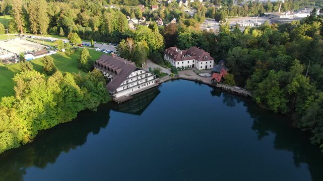 Tilt Down Aerial View of Dark Blue Turquoise Water in Slovenian Lake, Črnava. Colorful Landscape on Sunny Autumn Day. Drone Shot