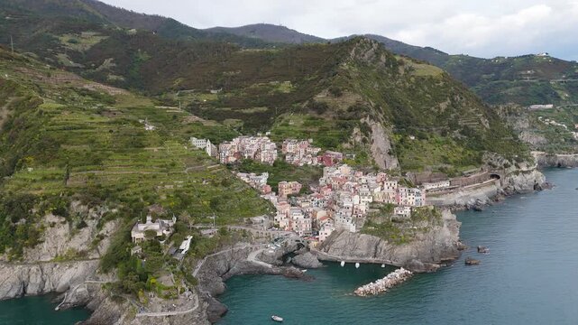 A distant side flight past Manarola &mdash; the village unfolds between sea, rock, and sky.