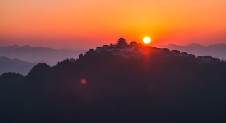 A breathtaking sunset over a mountain range, with the suns golden rays illuminating a hilltop village, creating a serene and picturesque landscape