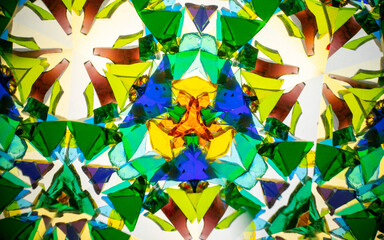 Natural kaleidoscope pattern captured with a camera, featuring vibrant stained glass colors and geometric symmetry.