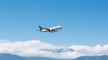 Fototapeta premium An airplane flies among the blue sky, clouds and mountains, showing the vastness and grandeur of air travel.