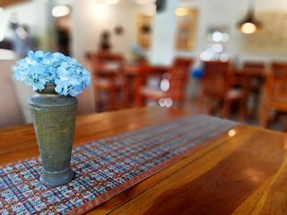Metal flower pot with blue Hortensia flower, on wooden table
