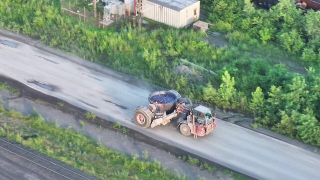 Drone footage of an industrial slag truck driving along the road.