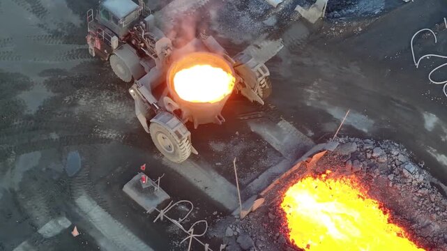 Overhead shot of industrial slag carrier pouring hot molten slag