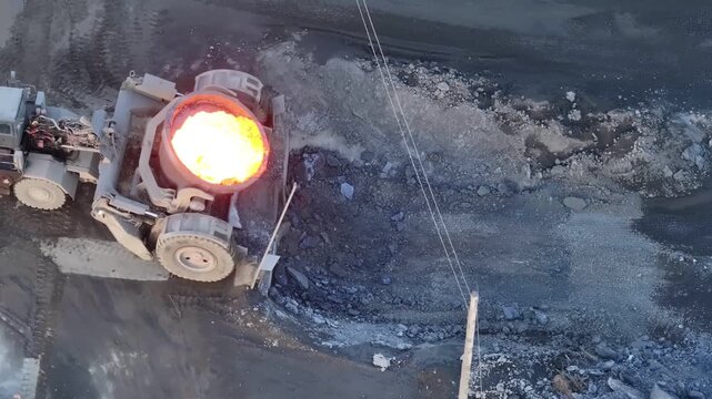 Overhead shot of industrial slag carrier pouring hot molten slag