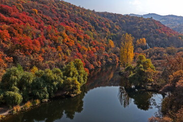 Soldier Lake. An urban lake surrounded by mountains with different vegetation. Autumn time, view from the drone.