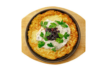 a large potato pancake in a frying pan with sauce and parsley