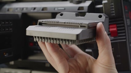 A skilled hand precisely positions an intricate electronic module.