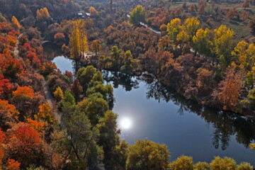 Soldier Lake. An urban lake surrounded by mountains with different vegetation. Autumn time, view from the drone.