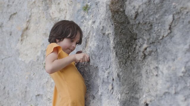 Children's rock climbing. A child climbs. Summer camp and holidays. Outdoor sports. - Powered by Adobe
