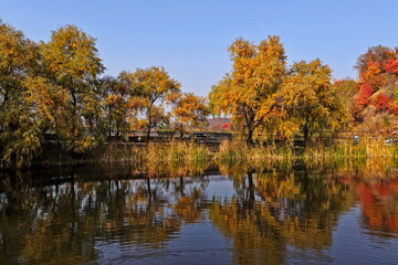 Soldier Lake. An urban lake surrounded by mountains with different vegetation. Autumn time, view from the drone.