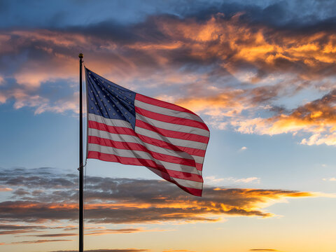 usa flag on pole against colorful dusk sky