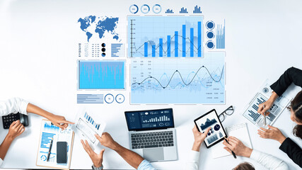 A top-down view of a collaborative meeting featuring charts, graphs, and digital devices, highlighting teamwork and data analysis in a modern office environment. Scalp