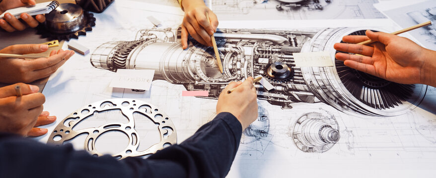 A dynamic group of people engaging in a mechanical engineering design session, surrounded by detailed technical drawings and tools, showcasing creativity and collaboration. SACTR