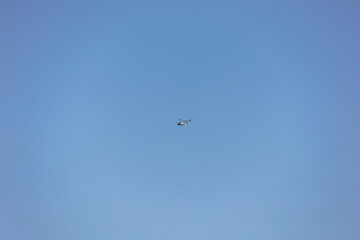A Minimalist Shot Of A Single Helicopter In Flight Against A Vast Expanse Of A Cloudless Blue Sky.