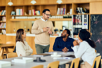 Professional Group Meeting With Presenter In Casual Cafe Space Sharing Ideas And Collaboration Among Colleagues