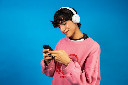 Young person smiling, listening to music, holding smartphone - Powered by Adobe