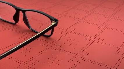 Stylish black framed glasses on vibrant coral background, photo concept