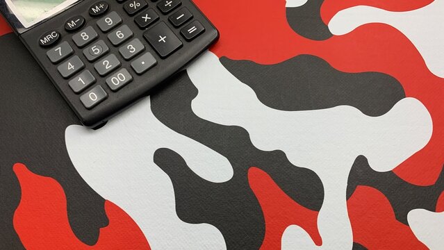 Calculate profits with sleek calculator on bold, modern red, white and black abstract background